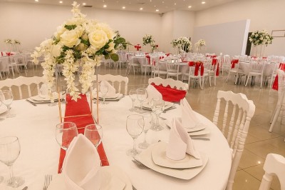 Miniature Location salle Fontenay-Trésigny (Seine-et-Marne) - L'Ecrin des Joyaux #5 Décor de mariage avec canapé blanc, table assortie et fleurs blanches et vertes sur une estrade ornée.