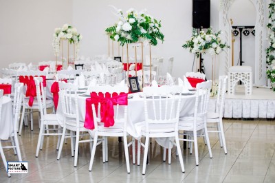 Miniature Location salle Fontenay-Trésigny (Seine-et-Marne) - L'Ecrin des Joyaux #7 Décor de mariage avec canapé blanc, table assortie et fleurs blanches et vertes sur une estrade ornée.