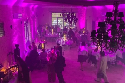 Salle de réception avec tables dressées et éclairage bleu projeté au plafond et sur le sol.