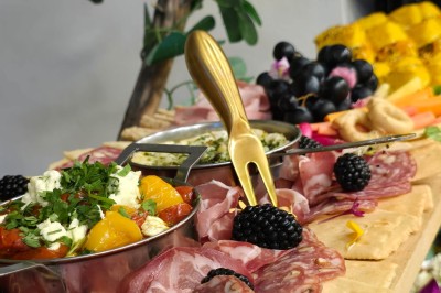 Table et deux chaises noires installées devant un mur beige avec une enseigne ’Nevian's Traiteur & Cave’.