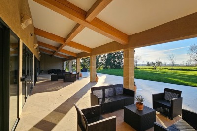 Miniature Location salle Arles (Bouches-du-Rhône) - Mas de la Grande Porcelette #9 Bâtisse en pierre avec une verrière, entourée d'une cour pavée et d'espaces verts sous un ciel dégagé.