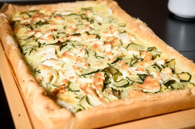 Une personne manipule une pâte à pizza en la faisant tourner dans un environnement de cuisine.