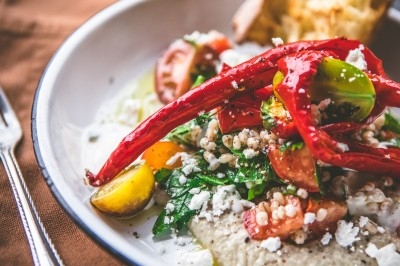 Une personne manipule une pâte à pizza en la faisant tourner dans un environnement de cuisine.