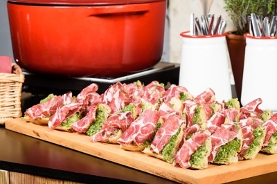 Une personne manipule une pâte à pizza en la faisant tourner dans un environnement de cuisine.