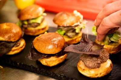 Une personne manipule une pâte à pizza en la faisant tourner dans un environnement de cuisine.