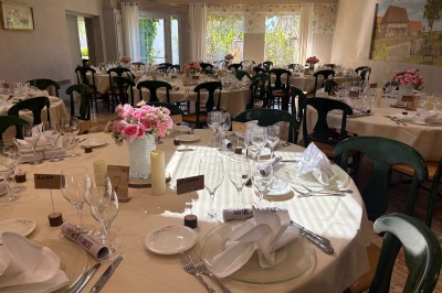 Miniature Location salle Condeissiat (Ain) - Restaurant Rolande #5 Une voiture Citroën 2CV rouge et blanche est garée devant un restaurant à façade fleurie dans un village.