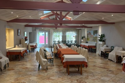 Miniature Location salle Condeissiat (Ain) - Restaurant Rolande #11 Une voiture Citroën 2CV rouge et blanche est garée devant un restaurant à façade fleurie dans un village.