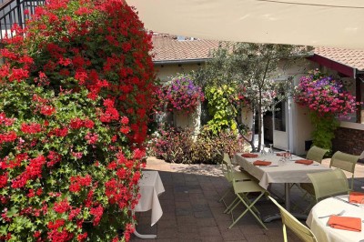Miniature Location salle Condeissiat (Ain) - Restaurant Rolande #14 Une voiture Citroën 2CV rouge et blanche est garée devant un restaurant à façade fleurie dans un village.