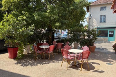 Miniature Location salle Condeissiat (Ain) - Restaurant Rolande #12 Une voiture Citroën 2CV rouge et blanche est garée devant un restaurant à façade fleurie dans un village.