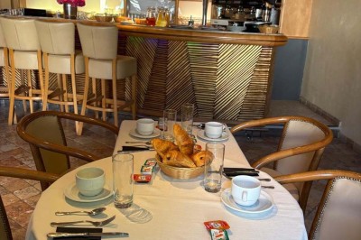 Miniature Location salle Condeissiat (Ain) - Restaurant Rolande #21 Une voiture Citroën 2CV rouge et blanche est garée devant un restaurant à façade fleurie dans un village.