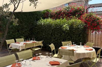 Miniature Location salle Condeissiat (Ain) - Restaurant Rolande #10 Une voiture Citroën 2CV rouge et blanche est garée devant un restaurant à façade fleurie dans un village.