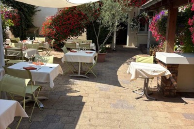 Miniature Location salle Condeissiat (Ain) - Restaurant Rolande #17 Une voiture Citroën 2CV rouge et blanche est garée devant un restaurant à façade fleurie dans un village.
