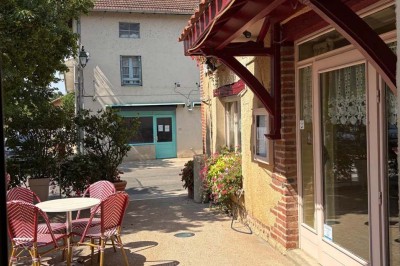 Miniature Location salle Condeissiat (Ain) - Restaurant Rolande #23 Une voiture Citroën 2CV rouge et blanche est garée devant un restaurant à façade fleurie dans un village.