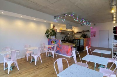 Salle vide avec parquet en bois clair, murs blancs, éclairage encastré au plafond et grande baie vitrée donnant sur l…