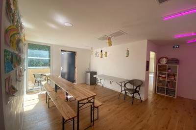 Décoration lumineuse avec le chiffre 18 éclairé et des ballons dorés et blancs dans une pièce sombre.