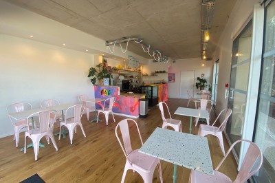 Décoration lumineuse avec le chiffre 18 éclairé et des ballons dorés et blancs dans une pièce sombre.