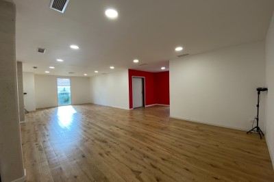 Décoration lumineuse avec le chiffre 18 éclairé et des ballons dorés et blancs dans une pièce sombre.