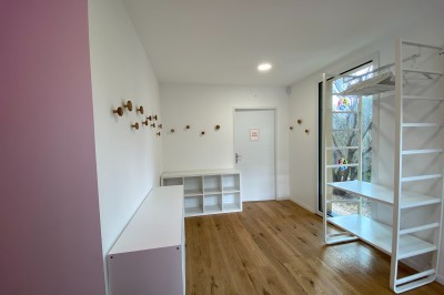 Décoration lumineuse avec le chiffre 18 éclairé et des ballons dorés et blancs dans une pièce sombre.