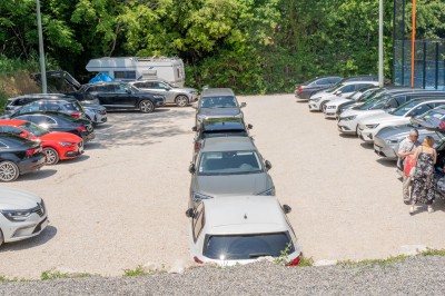Miniature Location salle Simiane-Collongue (Bouches-du-Rhône) - Restaurant du Cercle #12 Parking extérieur avec plusieurs voitures stationnées, entouré de végétation et d'un terrain de sport clôturé.