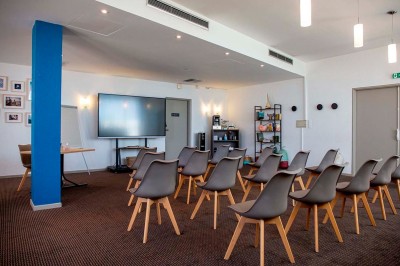 Miniature Salle de séminaire Deux lits simples avec tête de lit en bois décorée d'un motif de poisson, dans une chambre lumineuse et moderne.
