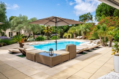 Salle de bain moderne avec lavabo blanc, miroir, étagère en bois, toilettes et serviettes pliées.