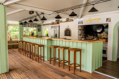 Salle de bain moderne avec lavabo blanc, miroir, étagère en bois, toilettes et serviettes pliées.
