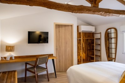 Salle de bain moderne avec lavabo blanc, miroir, étagère en bois, toilettes et serviettes pliées.