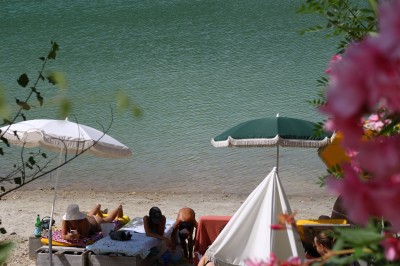 Vue aérienne d'un lac entouré de collines boisées sous un ciel dégagé au coucher du soleil.