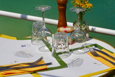 Vue aérienne d'un lac entouré de collines boisées sous un ciel dégagé au coucher du soleil.
