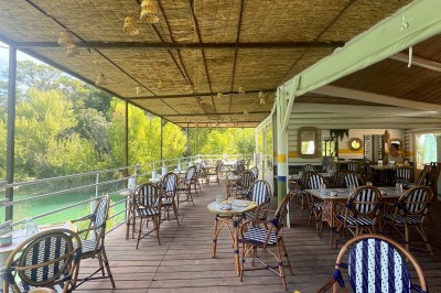 Vue aérienne d'un lac entouré de collines boisées sous un ciel dégagé au coucher du soleil.