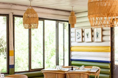 Vue aérienne d'un lac entouré de collines boisées sous un ciel dégagé au coucher du soleil.