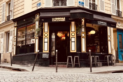 Bouteille de champagne dans un seau en métal, entourée de verres et d'un bouquet de fleurs, devant une tireuse à bière dorée.
