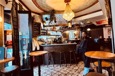 Bouteille de champagne dans un seau en métal, entourée de verres et d'un bouquet de fleurs, devant une tireuse à bière dorée.