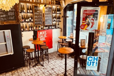 Bouteille de champagne dans un seau en métal, entourée de verres et d'un bouquet de fleurs, devant une tireuse à bière dorée.