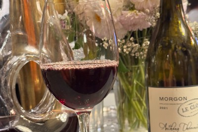 Bouteille de champagne dans un seau en métal, entourée de verres et d'un bouquet de fleurs, devant une tireuse à bière dorée.