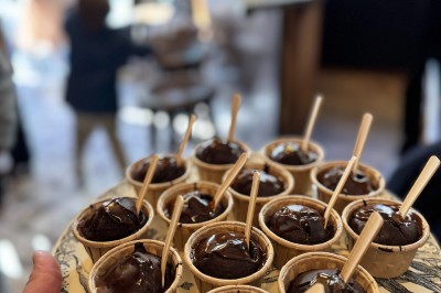 Bouteille de champagne dans un seau en métal, entourée de verres et d'un bouquet de fleurs, devant une tireuse à bière dorée.