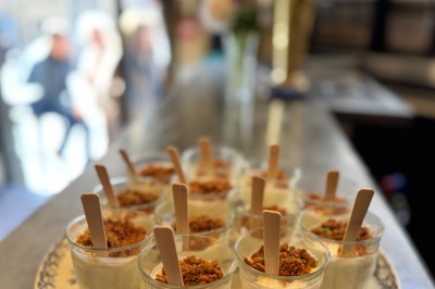 Bouteille de champagne dans un seau en métal, entourée de verres et d'un bouquet de fleurs, devant une tireuse à bière dorée.