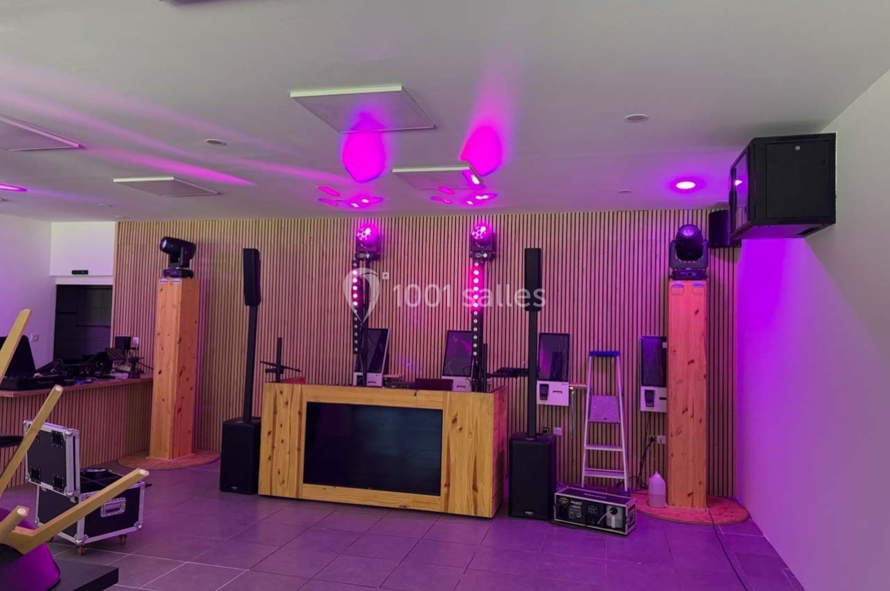 Installation de matériel de sonorisation et d'éclairage avec des lumières violettes dans une salle moderne.