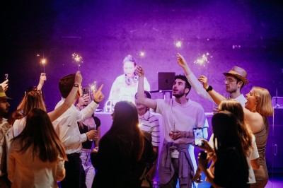 Comptoir en bois avec deux ordinateurs dans une salle d'arcade lumineuse, entourée de jeux et de machines.