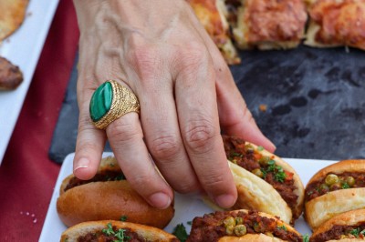 Cercle orné de motifs colorés entourant le mot ’OKRA’ sur un fond bleu foncé.