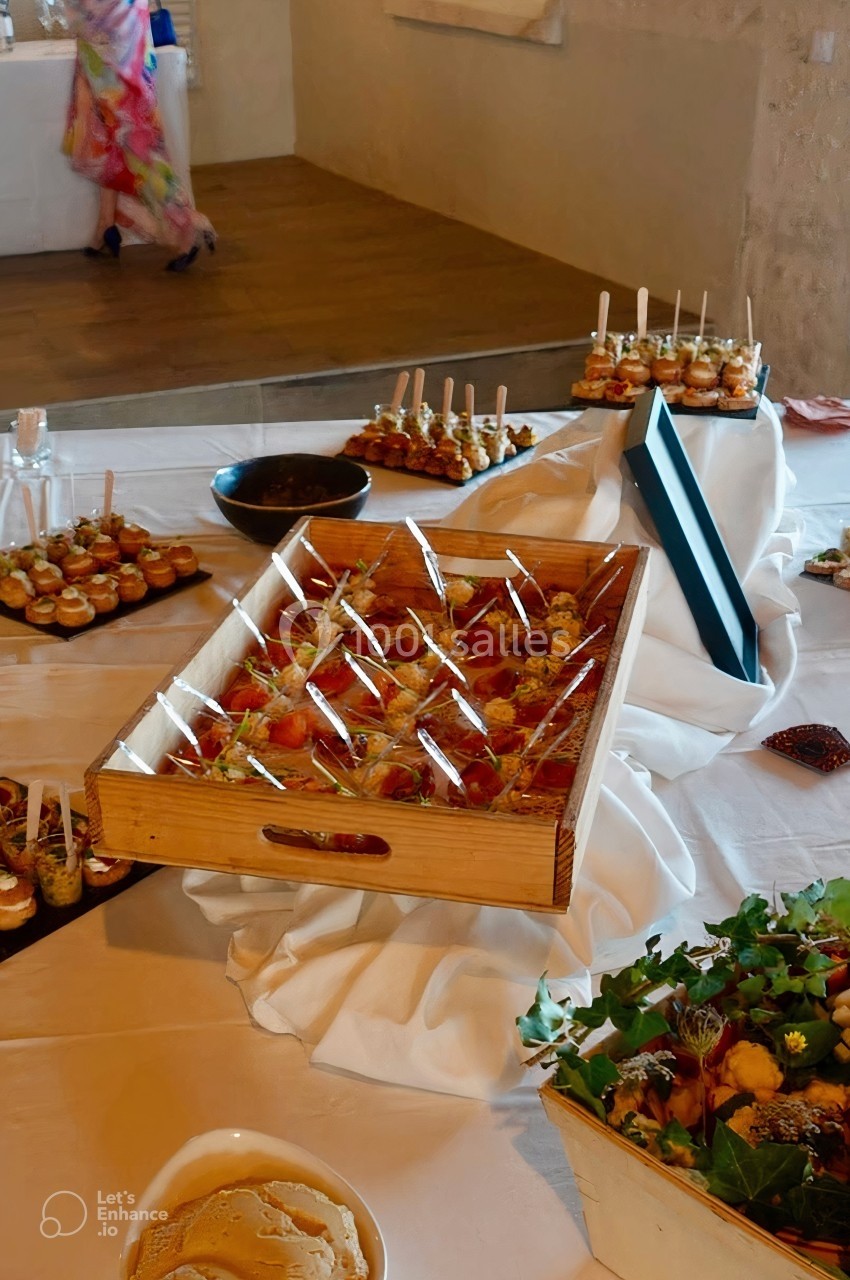 Plateau de verrines et amuse-bouches variés disposés sur une table blanche dans une salle de réception.