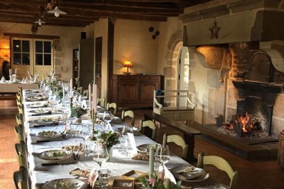 Miniature Location salle Broualan (Ille-et-Vilaine) - La Ferme du Domaine #7 Des poneys et une vache se reposent et broutent dans un pré clôturé, avec une cabane en bois en arrière-plan.