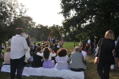 Miniature Location salle Broualan (Ille-et-Vilaine) - La Ferme du Domaine #11 Des poneys et une vache se reposent et broutent dans un pré clôturé, avec une cabane en bois en arrière-plan.