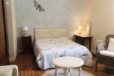 Miniature Location salle Broualan (Ille-et-Vilaine) - La Ferme du Domaine #25 Des poneys et une vache se reposent et broutent dans un pré clôturé, avec une cabane en bois en arrière-plan.