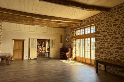 Miniature Location salle Broualan (Ille-et-Vilaine) - La Ferme du Domaine #18 Des poneys et une vache se reposent et broutent dans un pré clôturé, avec une cabane en bois en arrière-plan.