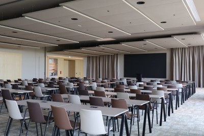 Miniature Destination Occitanie #9 Un groupe de personnes discute dans un jardin, entouré de plantes et d'arbres sous un ciel bleu.