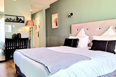 Miniature Location salle Sainte-Tulle (Alpes-de-Haute-Provence) - Domaine de la Mautanne #32 Chambre lumineuse avec lit double, murs verts, rideaux à motifs, lampe de chevet et décoration murale moderne.