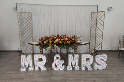 Assiette de crevettes grillées servies avec légumes et herbes fraîches, accompagnée de plats en arrière-plan.
