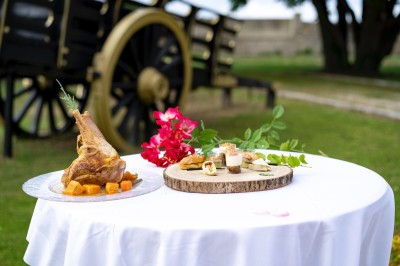 Assiette de crevettes grillées servies avec légumes et herbes fraîches, accompagnée de plats en arrière-plan.