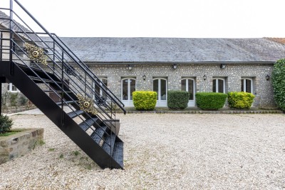 Assiette de crevettes grillées servies avec légumes et herbes fraîches, accompagnée de plats en arrière-plan.
